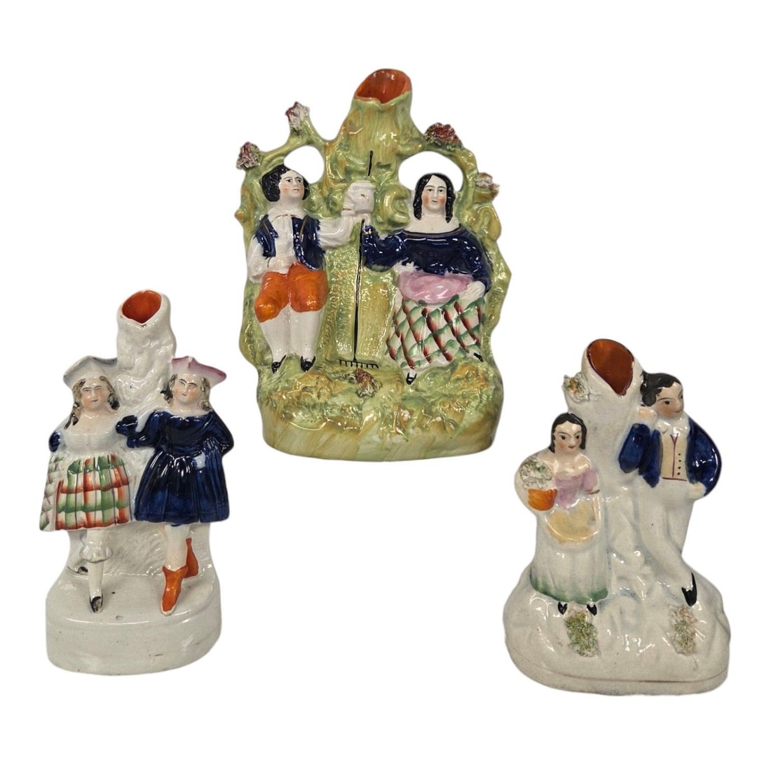 3 STAFFORDSHIRE SPILL VASES: This lot consists of 3 Staffordshire flatback spill vases. (1)The largest depicts a sitting couple holding a rake handle framed by a stylized tree with a central spill holder. Good condition except