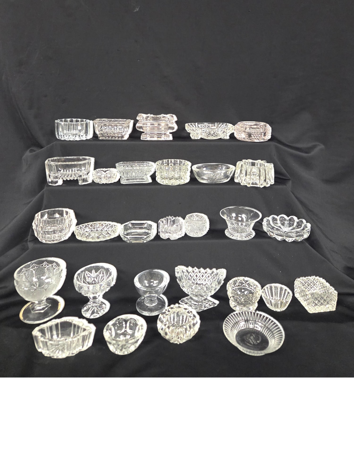 29 PC LOT OF GLASS SALT CELLARS: 29 piece lot of glass salt cellars. Includes a variety of small and master salts, pressed and cut glass. Good condition. See images