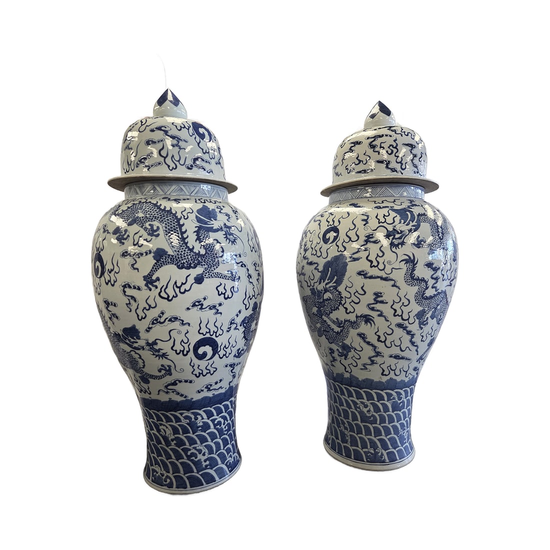 PR OF CHINOISERIE IMPERIAL DRAGON TEMPLE/GINGER JARS: Pair of Chinoiserie Imperial Dragon blue and white Temple Jars or Ginger Jars from Tozai Home. Crafted from heavy high fired porcelain with a glossy glazed finish. The main body displays a detailed mo