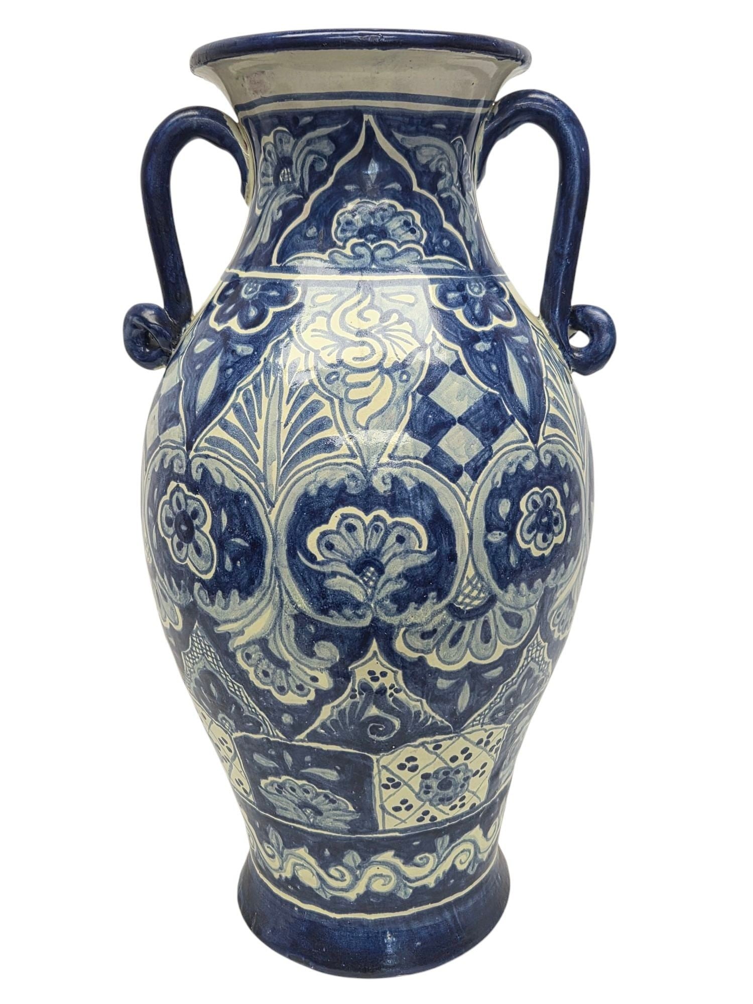 ARTIST SIGNED TALVERA BLUE WHITE HANDLED VASE: Hand painted decorative blue and white Talavera vase with handles measuring 20 H x 12 W. Slight chips and imperfections throughout due to hand made craftsmanship and glazing. Two larger broken areas