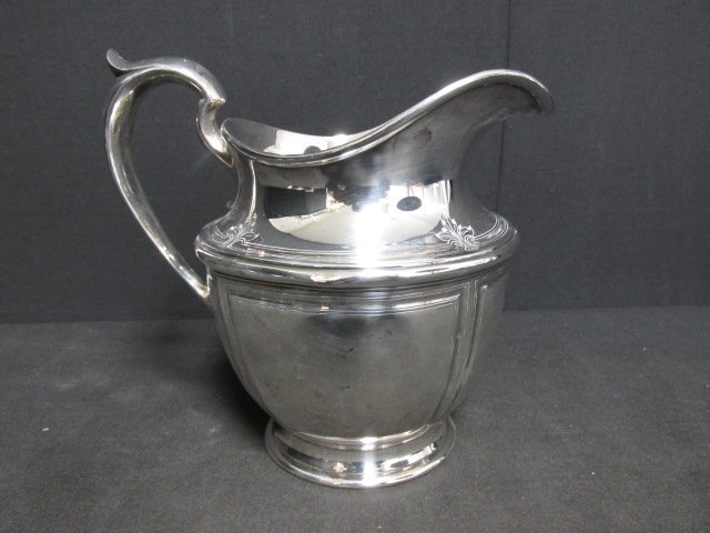 STERLING SILVER WATER PITCHER: Early 20th century sterling silver 4 1/2 pint pitcher. Measures: 8 3/4" tall and 9" handle to spout. Stamped Sterling with a "D" hallmark. Condition: good with few small dings, monogrammed. See images