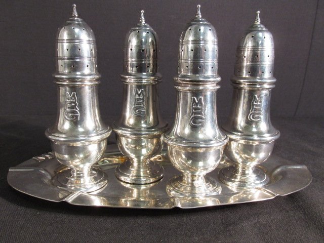 FIVE PIECE STERLING SILVER MASTER SALT & PEPPER SET: Five piece sterling silver master salt and pepper set. Includes (4) 5.5" tall master shakers, and (1) 10.25" long oval tray. Each piece is monogrammed "MRG", and is stamped on base "Sterling". Conditi