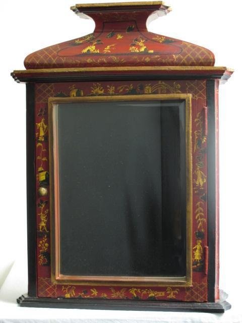 CHINOISERIE HAND PAINTED RED LACQUER WALL: A Chinoiserie hand painted red lacquer pagoda style medicine cabinet or wall cupboard with a mirrored front door. Interior features three shelves and a hand painted door back. Condition: good, very mi