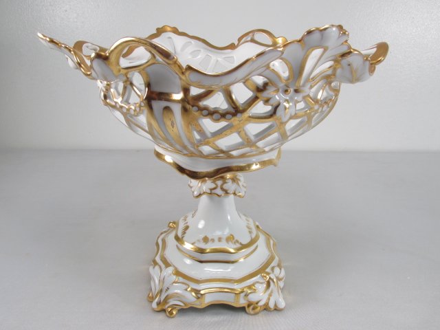 OLD PARIS PORCELAIN RETICULATED CENTERPIECE: Old Paris porcelain reticulated centerpiece. White glazed porcelain with gilt details. Two piece porcelain with center metal joining rod. Measures 10" tall by 11" wide. Condition: rusting bolt at bott