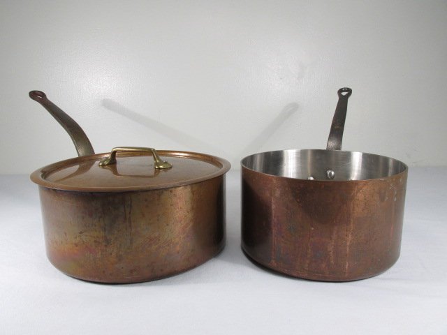 TWO VINTAGE DEHILLERIN COPPER POTS: Lot of two vintage copper pots by Dehillerin, France. Includes a pot measuring 9.5" in diameter x 5.5" tall (18.5" total length with handle), and a pot with a diameter of 11.25" x 5" tall (21.75" tota