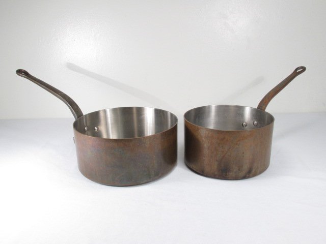 TWO VINTAGE DEHILLERIN COPPER POTS: Lot of two vintage copper pots by Dehillerin, France. Includes a larger with a diameter of 11.25", and a smaller pot at 9.5" diameter. Larger pot measures a total of 21.75" including handle. Both piec