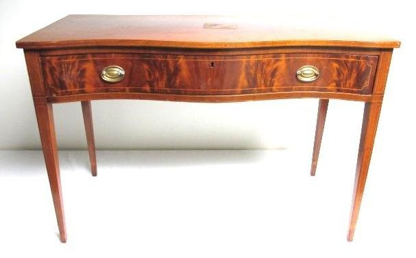 REGENCY SERPENTINE FRONT DESK: Regency serpentine front desk with a rosewood veneer front drawer, original hardware (backs replaced), banded inlays, and tapered legs. Condition: wear consistent with age, area of water damage to des
