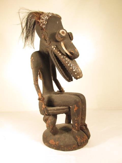 PAPUA NEW GUINEA TIGOWI CARVED WOOD ANCESTRAL FIGURE: Papua New Guinea carved wood crocodile ancestral figure depicting "Kumbianmu", from the Tigowi tribe. Inlaid with various shells, bone, and cassowary feathers. Condition: minor losses to finish, no ma