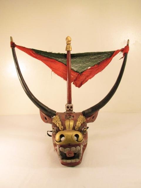 INDONESIAN CARVED & PAINTED WOOD BULL MASK: Indonesian carved and painted wood mask depicting a three eyed bull with a spike in it's head. Fabric scarf tied between horns for decoration. Condition: good, no signs of damage or repair, see images