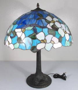 TIFFANY STYLE STAINED & LEADED GLASS TABLE LAMP: Tiffany style stained and leaded glass table lamp. Floral pattern with a patinated metal base. Fitted with a single bulb fixture. Measures a total of 25" tall. Condition: very minor signs of wear and