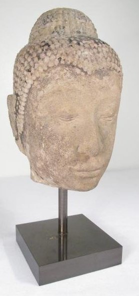 THAI CARVED STONE BUDDHA HEAD: Thai carved stone Buddha head mounted on a square metal base. Remains of a finish and gilding can be found in areas. Condition: heavy signs of age and wear, small losses to each ear lobe, blemish to m