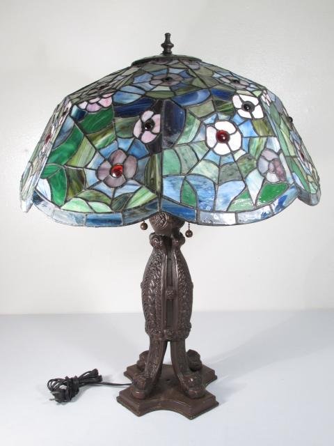 TIFFANY STYLE STAINED AND LEADED GLASS TABLE LAMP: Tiffany style stained and leaded glass table lamp with a colorful hand-made floral pattern shade. Unmarked as to maker, and with a unique painted metal base. Condition: good, no chips or cracks, to gl