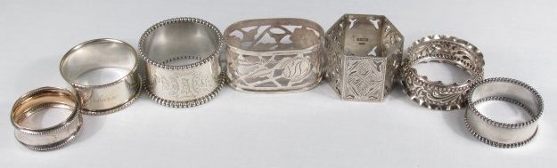 SEVEN ASSORTED 19TH CENTURY SILVER NAPKIN RINGS: Lot of seven assorted 19th century silver napkin rings. Includes (6) sterling silver, and (1) small 830 silver ring. Three are monogrammed/personally engraved. Condition: good, very minor signs of age