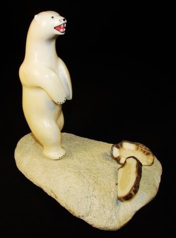 DELBERT SEETOT MARINE IVORY BEAR FIGURE: An inuit carving of an marine ivory bear with two pieces of petrified walrus rusk mounted on whale bone base by artist Delbert Seetot, signed on bottom. Measurements: 7" tall x 7.5" long x 3" wide. Co
