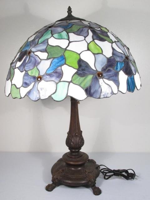 TIFFANY STYLE LEADED & STAINED GLASS TABLE LAMP: Tiffany style leaded and stained glass table lamp. Combination of stained and slag glass pieces leaded together with a painted finish metal base and three bulb fixture. Unmarked as to maker. Condition