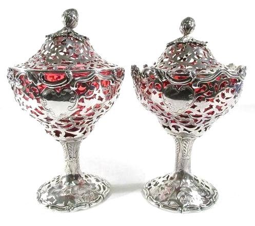 PAIR J. ANGELL I & II STERLING SILVER COMPOTES: A pair of reticulated sterling silver lidded compotes with ruby liners and acorn finials. Each well hallmarked for Joseph Angell I and Joseph Angell II with the quatrefoil double J.A. hallmark. Circa 