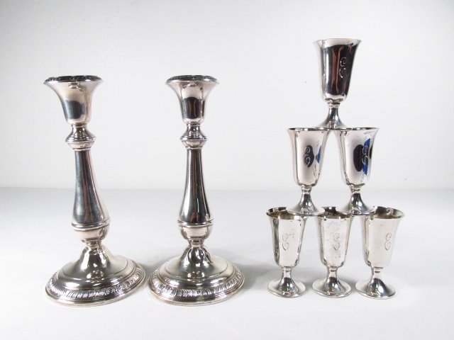 SIX TOWLE STERLING APERITIF CUPS & PAIR CANDLESTICKS: Six sterling silver aperitif cups by Towle, sold along with a pair of Revere silversmith weighted sterling silver candlesticks. Each cup measures 3" tall, candlesticks each measure 8" tall. Condition: