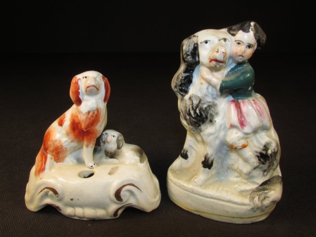 TWO SMALL STAFFORDSHIRE CERAMIC FIGURINES: Lot of two small Staffordshire porcelain figurines. Includes a 2.9" tall pen holder with two dogs, and a small 3.75" tall figure of a young girl hugging a dog. Condition: minor paint loss, repair to f