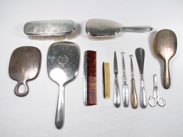 STERLING SILVER VANITY DRESSER SETS, TWELVE PIECES: A group of (12) Sterling silver vanity, dresser accessories including: (2) hand mirrors, (3) brushes, (2) combs, (2) button hook, scissors, nail file and shoe horn. Measurements: Largest hand mirror i