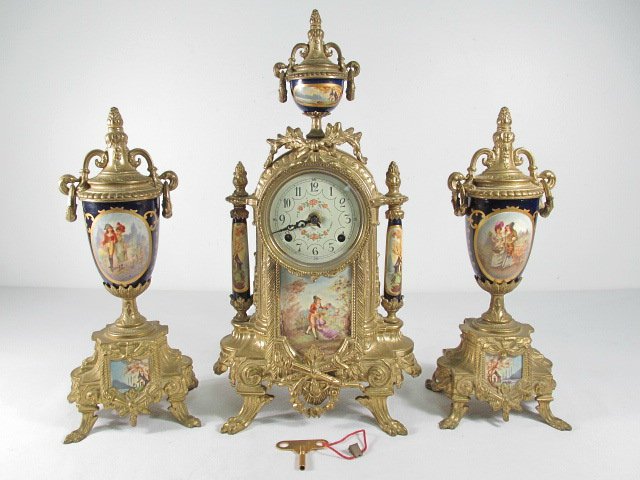 FRANZ HERMELE MANTEL GARNITURE SET: 3 PCS: Franz Hermele Italian mantel garniture set. Includes (2) 12.5" tall urn form garnitures, and a 16.25" tall mantel clock with a Franz Hermele double chime German movement. Porcelain mounts throughout.