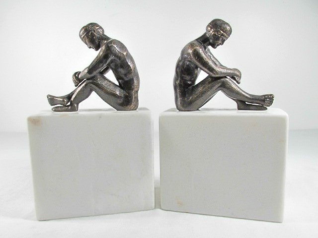 PAIR ART DECO IRON & MARBLE NUDE FIGURE BOOKENDS: Pair of Art Deco patinated iron bookends with white marble bases. Each bookend depicts a nude man sitting. Unsigned. Condition: very minor discoloration to marble, no chips or cracks, see images. Each
