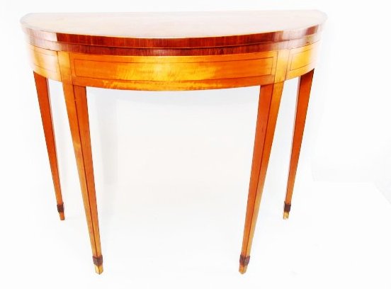 FEDERAL INLAID SATINWOOD DEMILUNE GAMES TABLE: Federal inlaid satinwood demilune flip-top games table, circa early 19th century, measuring 29.75" tall x 36" wide x 18.25" deep (when flipped closed). Surface of games table lined with green felt. Tw
