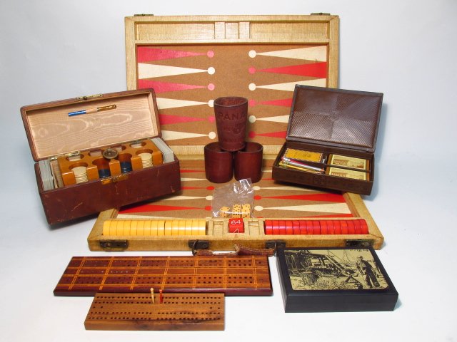 VINTAGE GAME LOT: BACKGAMMON, POKER, CRIBBAGE & CARDS: A group of vintage board games, cribbage boards, a backgammon set with bakelite discs, a poker set with clay chips in a leather (sharkskin?) case, leather dice cups, and a leatherlike card case with c