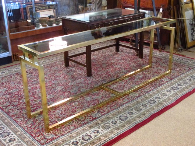 BRASS & GLASS SOFA OR HALL TABLE: Brass and glass sofa or hall table measuring . Dark tinted glass top. Condition: signs of wear and some scuffs to brass finish, see images. Measures 29" tall x 78" long and 14" deep. Weight: approx. 3