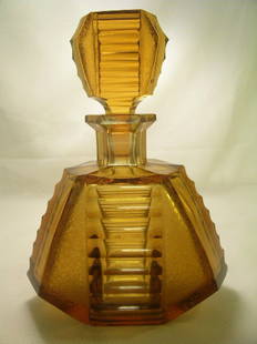 AMBER CRYSTAL GLASS ART DECO DECANTER BOTTLE: Lot 5: AMBER CRYSTAL GLASS ART DECO DECANTER BOTTLE - Measures 9 1/2" tall x 7" wide. Small flake on bottom of decanter. Good condition.