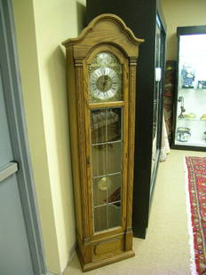 20th CENTURY NATURAL WOOD FINISH GRANDMOTHER CLOCK: Lot 540: 20th CENTURY NATURAL WOOD FINISH GRANDMOTHER CLOCK - Time strike at quarter hour. Three weights. Millioned glass on front door. Measures 18" wide x 9" deep x 73" tall. Slight scratches to