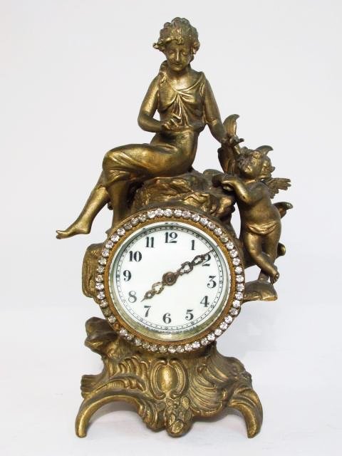 NEW HAVEN FIGURAL PATINATED METAL SHELF CLOCK: New Haven Rococo style patinated metal shelf clock measuring 9.25" tall x 5.5" wide. Condition: generally good, some signs of age/wear, one glass gemstone missing from around face, see images. Weight: