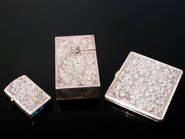 ITALIAN .800 SILVER LIGHTER, CIGARETTE CASE & BOX: Three pieces of Italian .800 silver - all smoking accoutrements. Includes a silver zippo lighter, cigarette case, and cigarette box. Cigarette case measures 3.5" wide x 3.15" long x .4" deep. Cigarett
