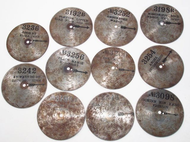 PERFORATED METAL PLAYER PIANO OR MUSIC BOX SONG DISCS: A number of assorted player piano or music box song discs. Condition: most retain printed song name, etc, all appear to be in usable condition, see images. Largest measure 9" in diameter. Smallest 5".