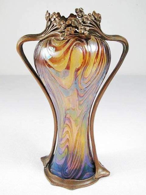 JOSEF RINDSKOPF ART NOUVEAU METAL MOUNTED GLASS VASE: Josef Rindskopf Art Nouveau metal mounted art glass vase. Pulled multicolored glass, with a floral mounting. Unsigned but for small mark on metal base. Condition: a few small flakes and chips to rim, 