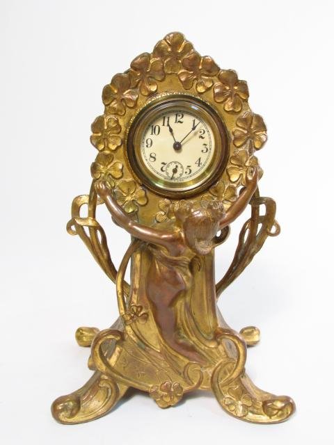 ART NOUVEAU FIGURAL GILDED METAL CLOCK: Art Nouveau figural gilded metal clock measuring 9.5" tall x 6.5" wide x 4.5" deep. Unmarked by maker on face but for "Made in USA". Condition: good, original movement, wear through gilding in areas,