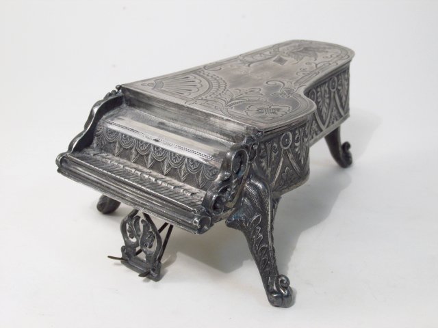 VICTORIAN RACINE SILVER PLATED PIANO FORM JEWELRY BOX: Victorian Racine Silver Plated piano form jewelry box measuring 7" long x 2.8" tall. Marked on base. Condition: original liner, minor signs of wear/age to finish, see images. Weight: 1 lb.