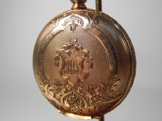 WALTHAM 14K GOLD 1896 HUNTER CASE POCKET WATCH: Waltham 14k gold 1986 hunter's case pocket watch. Intricately engraved case with monogram at the front. Engraved with the name "Jessie M. Simmons" inside back cover. Marked "14k" with A.W.C. Co logo i
