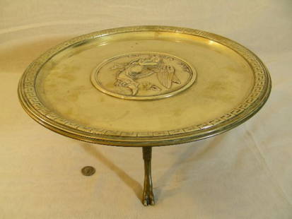 ENGLISH AESTHETIC DESIGN BRASS ANIMAL FOOT TAZZA: Lot 1116: ENGLISH AESTHETIC DESIGN BRASS ANIMAL FOOT TAZZA - Measures 11 1/2" wide by 5 1/2" tall. Disc top with greek key boarder and center medallion depicting angel with children titled ET ROMA