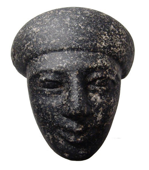 Granite facial portion from a sarcophagus: A diorite granite facial portion from a sarcophagus, the features well carved with a solemn expression. Intact with good surfaces. Hagan Collection, MI H: 6" (15.2 cm)