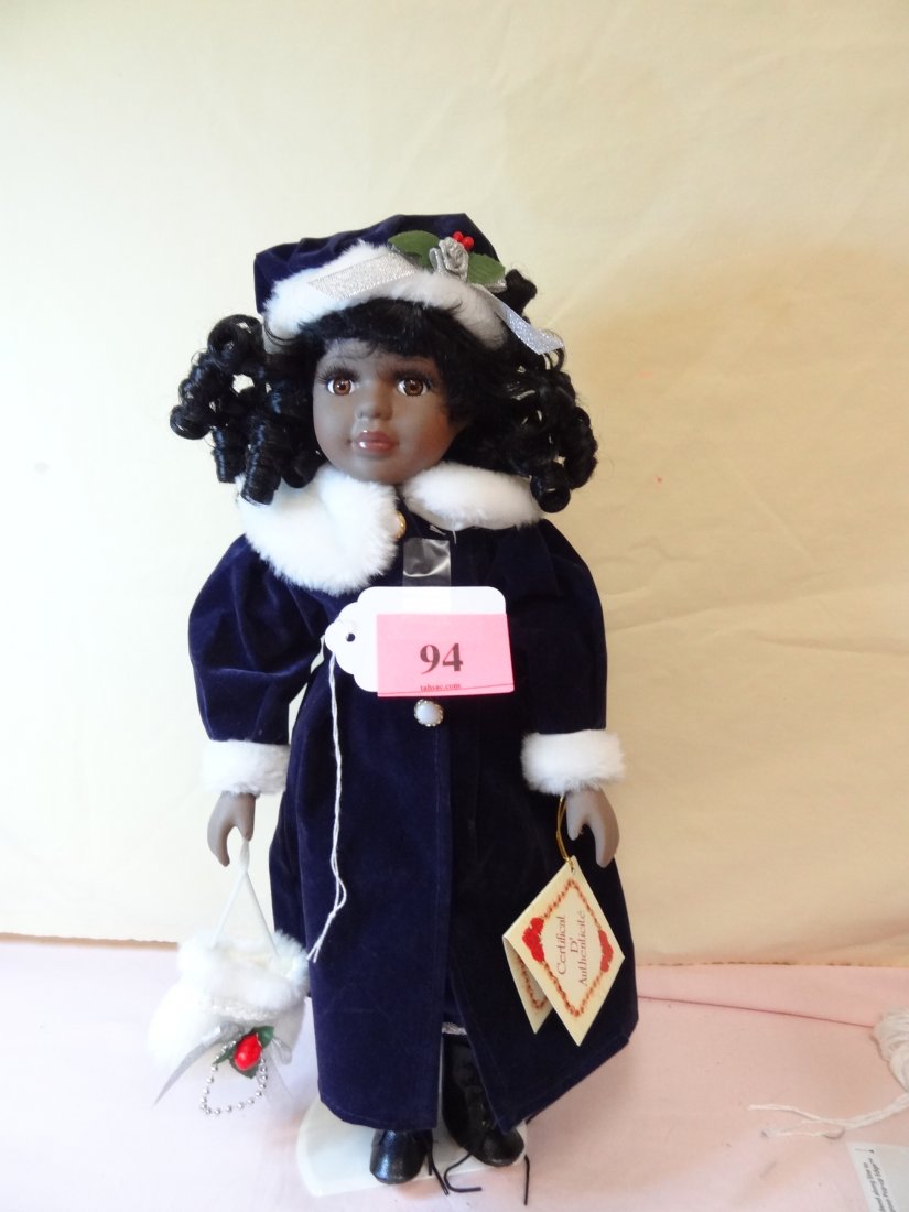 16'' AFRICAN AMERICAN MODERN DOLL. PORCELAIN HEAD A: 16'' AFRICAN AMERICAN MODERN DOLL. PORCELAIN HEAD AND LIMBS, SOFT CLOTH BODY. ''COLLECTOR'S CHOICE CLUB'' DOLL. SHE'S DRESSED IN HER WINTER COAT AND HAT. BROWN EYES AND BLACK HAIR.