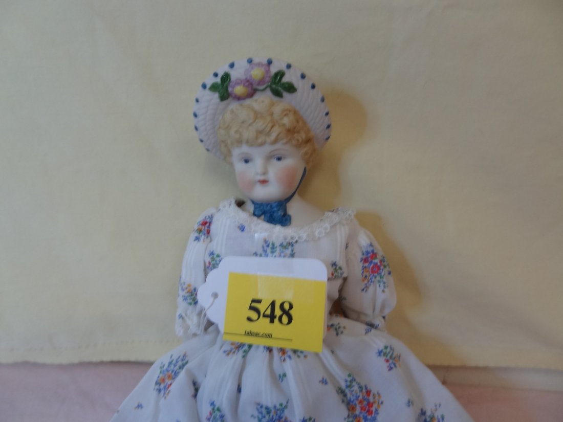 15'' BONNET HEAD DOLL, BISQUE HEAD AND SHOULDERS,: 15'' BONNET HEAD DOLL, BISQUE HEAD AND SHOULDERS, HANDS AND FEET, PAINTED BLONDE HAIR, BLUE PAINTED EYES, BLACK PAINTED BOOTS, WHITE DRESS WITH PINK AND BLUE FLOWER DRESS, NO MARKS