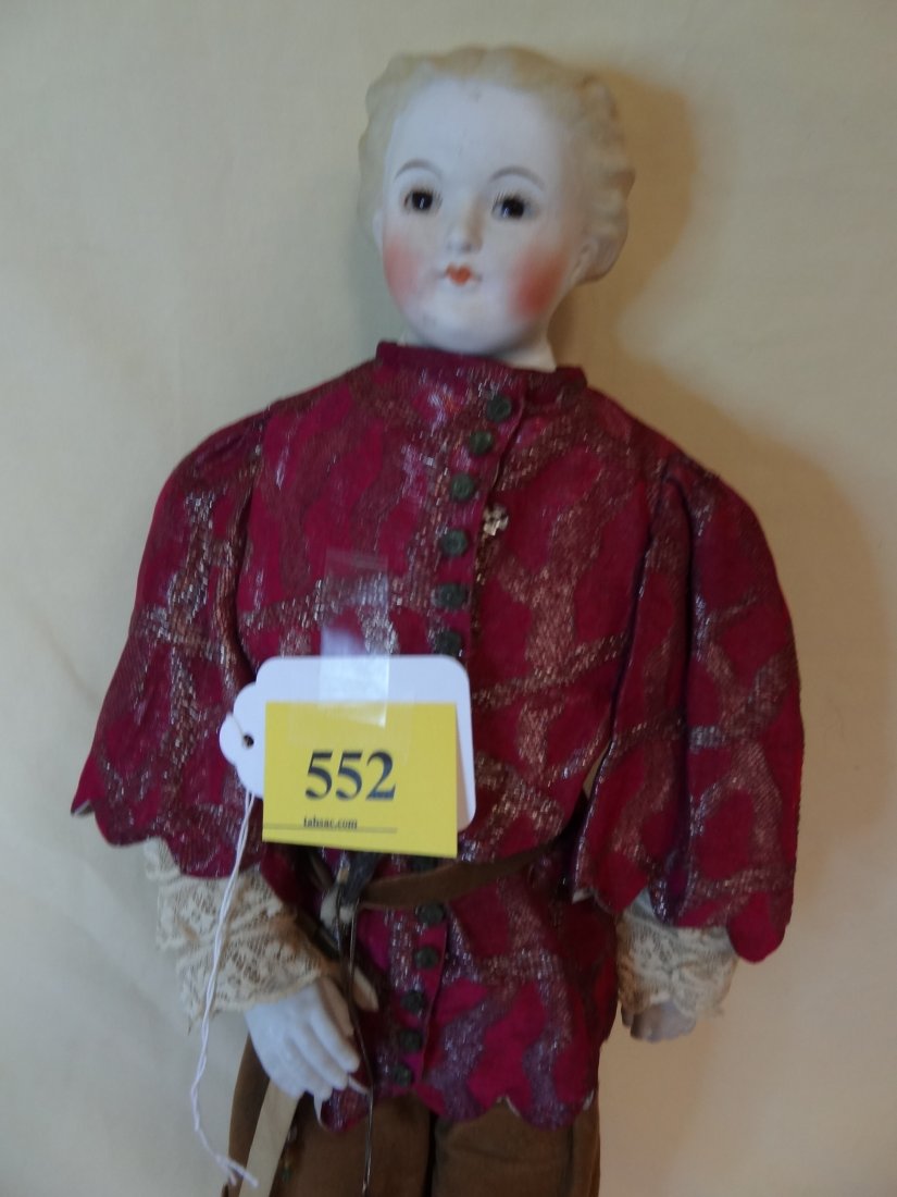 21'' MOLDED BISQUE HEAD AND SHOULDER, HANDS AND LE: 21'' MOLDED BISQUE HEAD AND SHOULDER, HANDS AND LEGS, PAINTED BLONDE HAIR, BROWN GLASS EYES, PAINTED FANCY BOOTS, DRESSED AS A CHRISTIAN CRUSADER IN LEATHER PANTS, FANCY TOP WITH GREEN SATIN CAPE, SWO