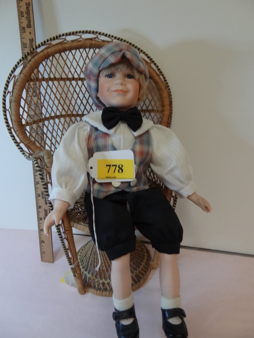 15'' DOLL, SITTING 10'' HIGH, BISQUE HEAD AND LIMB: 15'' DOLL, SITTING 10'' HIGH, BISQUE HEAD AND LIMBS WITH SOFT CLOTHE BODY, BLONDE HAIR BLUE GLASS EYES GENTLEMENLY SMILE, DRESSED IN A GOLFER DAPPER TYPE OUTFIT WITH BOW TIE. PLAD HAT AND VEST WITH BL
