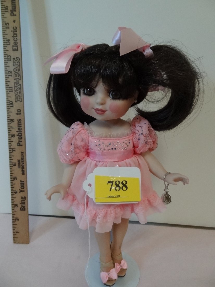 12'' MARIE OSMOND DOLL, "2008, #2950", ALL BISQUE: 12" MARIE OSMOND DOLL, "2008 #2950", ALL BISQUE DOLL WITH JOINTED LIMBS, BROWN HAIR IN TWO PIG TAILS WITH TWO PINK BOWS, WEARING A PINK DRESS, ROSY LIPS AND PINK CHEEKS WITH DIMPLES, LARGE BROWN EYES