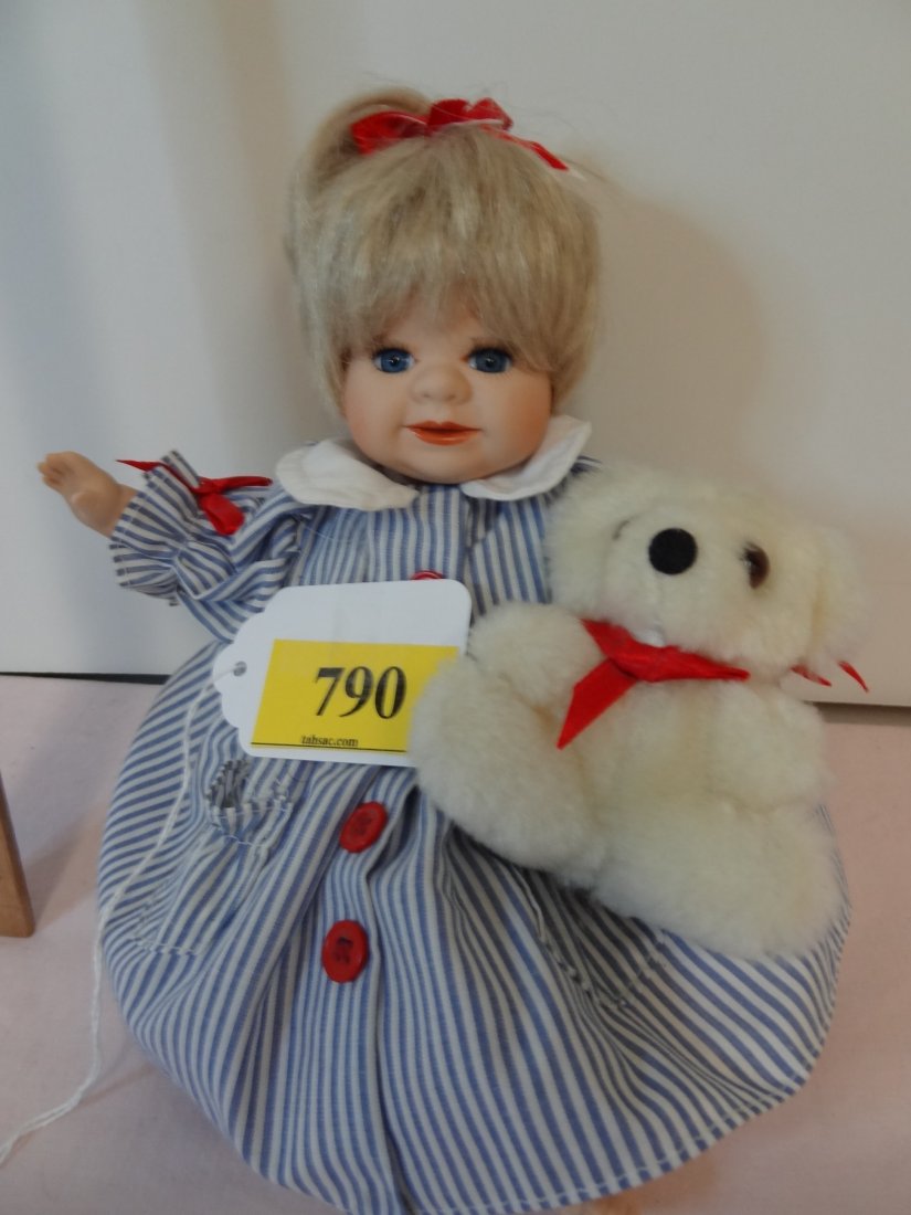 8'' HIGH SITTING,MARKED: MANN, DESIGNED BY MICHELE: 8'' HIGH SITTING,MARKED: MANN, DESIGNED BY MICHELE SEVERINO EXCLUSIVELY FOR SEYMOUR MANN INC 1995 #1400/7500, STAMPED IMPRESSION 1991; BISQUE HEAD AND LIMBS WITH CLOTHE BODY, HOLDING SMALL TEDDY BEAR,