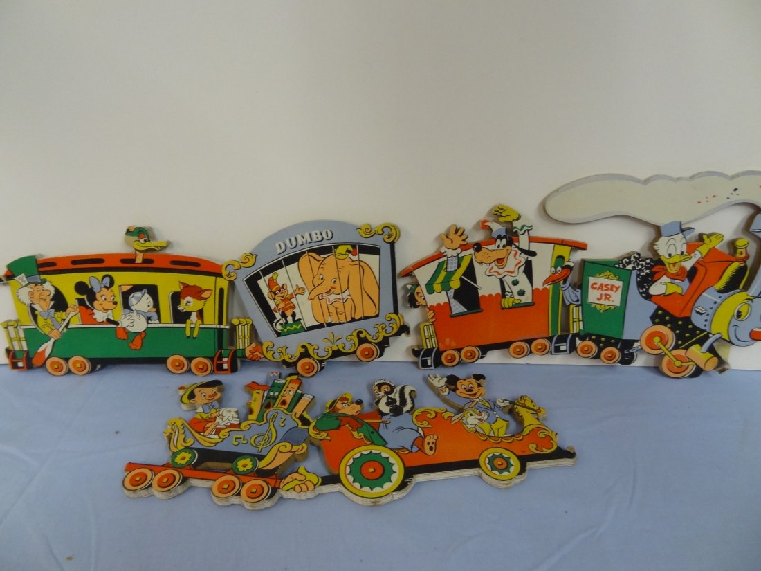 THREE VINTAGE WALT DISNEY ITEMS; CARDBOARD BABY NURSERY: THREE VINTAGE WALT DISNEY ITEMS; CARDBOARD BABY NURSERY TRAIN WALL PLAQUE WITH DISNEY CHARACTERS; 1975 MICKEY MOUSE MYSTERY AT DISNEYLAND PAPERBACK BOOK AND THE DISNEY WORLD OF POSTAGE STAMPS ALBUM.