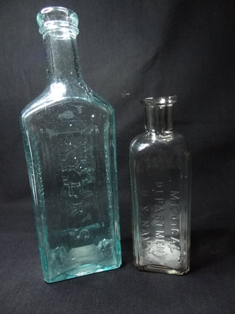 VINTAGE BOTTLES - TWO OLD BOTTLES; AYER'S / SARSAPARILL: VINTAGE BOTTLES - TWO OLD BOTTLES; AYER'S / SARSAPARILLA / COMPOUND EXT. / LOWELL MASS. USA. AQUA BOTTLE 8.5'' X 2 5/8'' X 1 3/4''; CLEAR BOTTLE READS: MEDICAL DEPARTMENT U.S. NAVY, 200 MILS, 6'' TALL