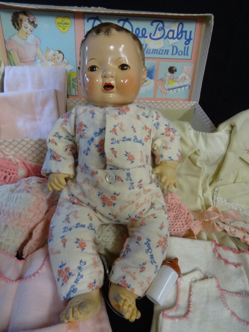 EFFANBEE DY-DEE BABY WITH BOX OF CLOTHES; COMPOSITION M: EFFANBEE DY-DEE BABY WITH BOX OF CLOTHES; COMPOSITION MOLDED HEAD WITH RUBBER BODY AND HARD RUBBER JOINTED LIMBS, 15.5'' TALL, BROWN GLASS EYES, BROWN PAINTED HAIR, ROSY CHEEKS AND LIPS, OPEN MOUTH SM