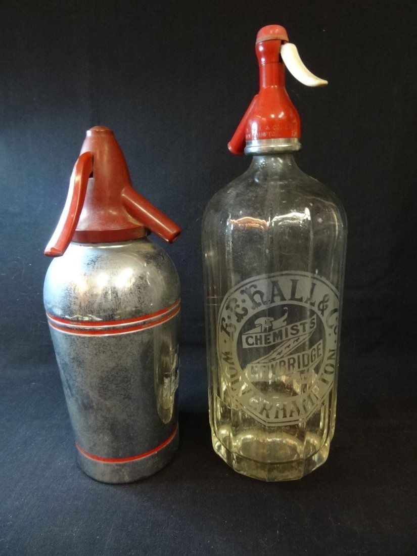 TWO VINTAGE SELTZER BOTTLES: 1) METAL WITH RED TOP MARK: TWO VINTAGE SELTZER BOTTLES: 1) METAL WITH RED TOP MARKED SPARKLET DEVICES, INC. 10'' TALL, GOOD CONDITION. 2) GLASS BOTTLE WITH RED PLASTIC TOP MARKED E.E. HALL & CO. WOLVERHAMPTON, CHEMISTS NEWBRIDG