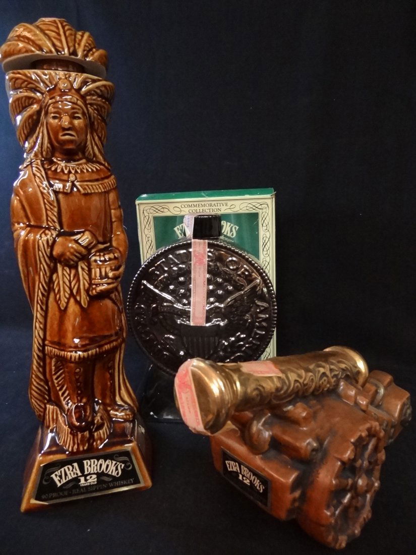 THREE VINTAGE EZRA BROOKS REAL SIPPIN' WHISKEY DECANTER: THREE VINTAGE EZRA BROOKS REAL SIPPIN' WHISKEY DECANTERS: 1) 1804 SILVER DOLLAR GENUINE FIRED PLATINUM, 4/5 QUART, 9.5'' TALL, 2) ANTIQUE CANNON, 7'' TALL, 3) CIGAR STORE INDIAN, 4/5 QUART, 15 1/2'' T